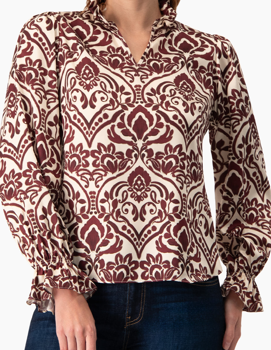 Blusa vino con estampado floral, cuello alto y escote en V